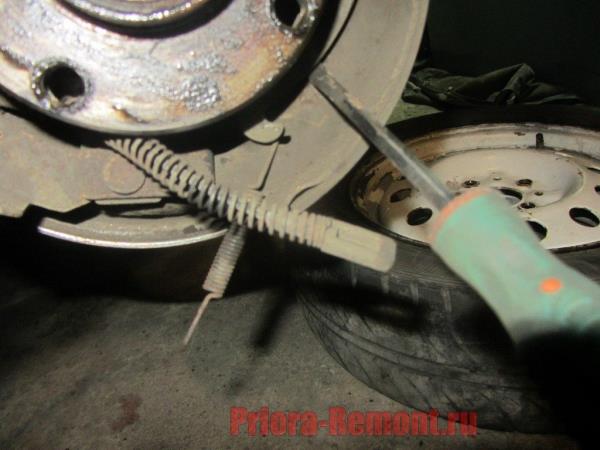 вытащить трос ручника из рычага привода на Приоре